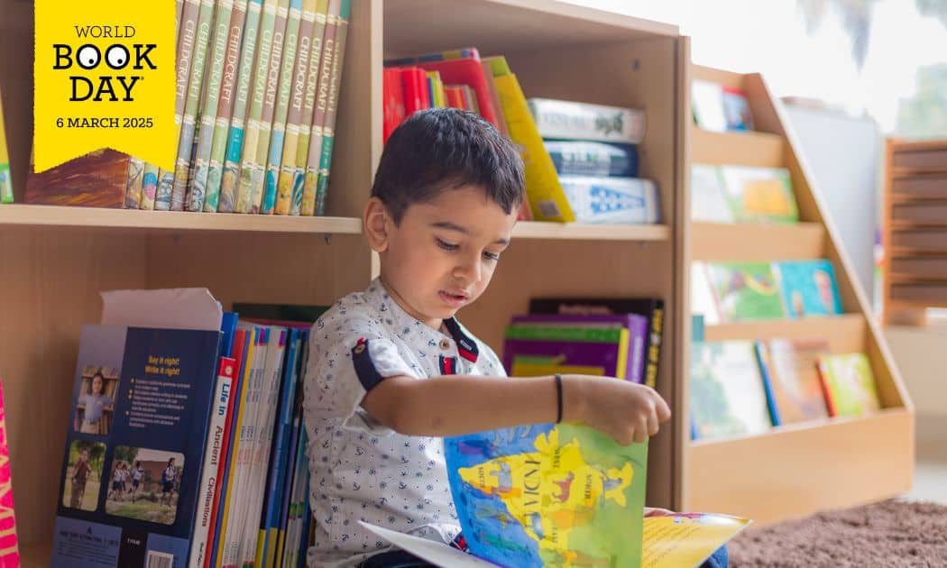 A pic of student at Kidoz Montessori reading a book with a yellow banner superimposed with the words World Book Day